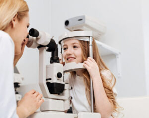 Young girl having her eyes examined at doctor office