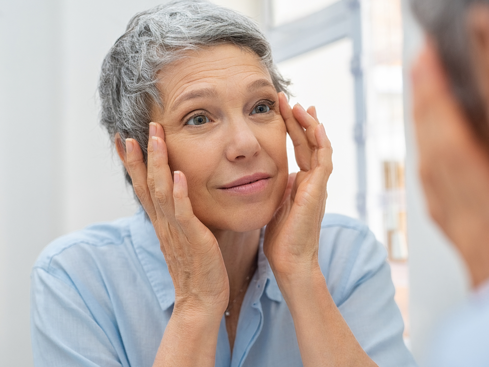 Woman looking in the mirror at her eyes