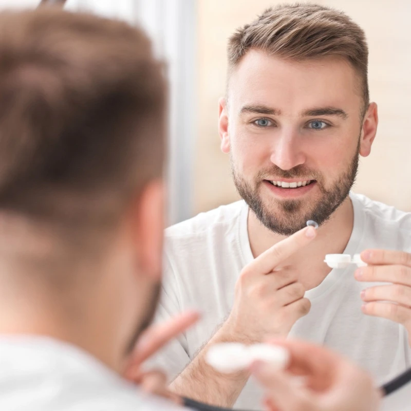 man putting in his contact lenses